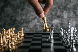 mao-de-homem-jogando-xadrez-para-planejamento-de-negocios-e-comparacao-de-metafora-foco-seletivo